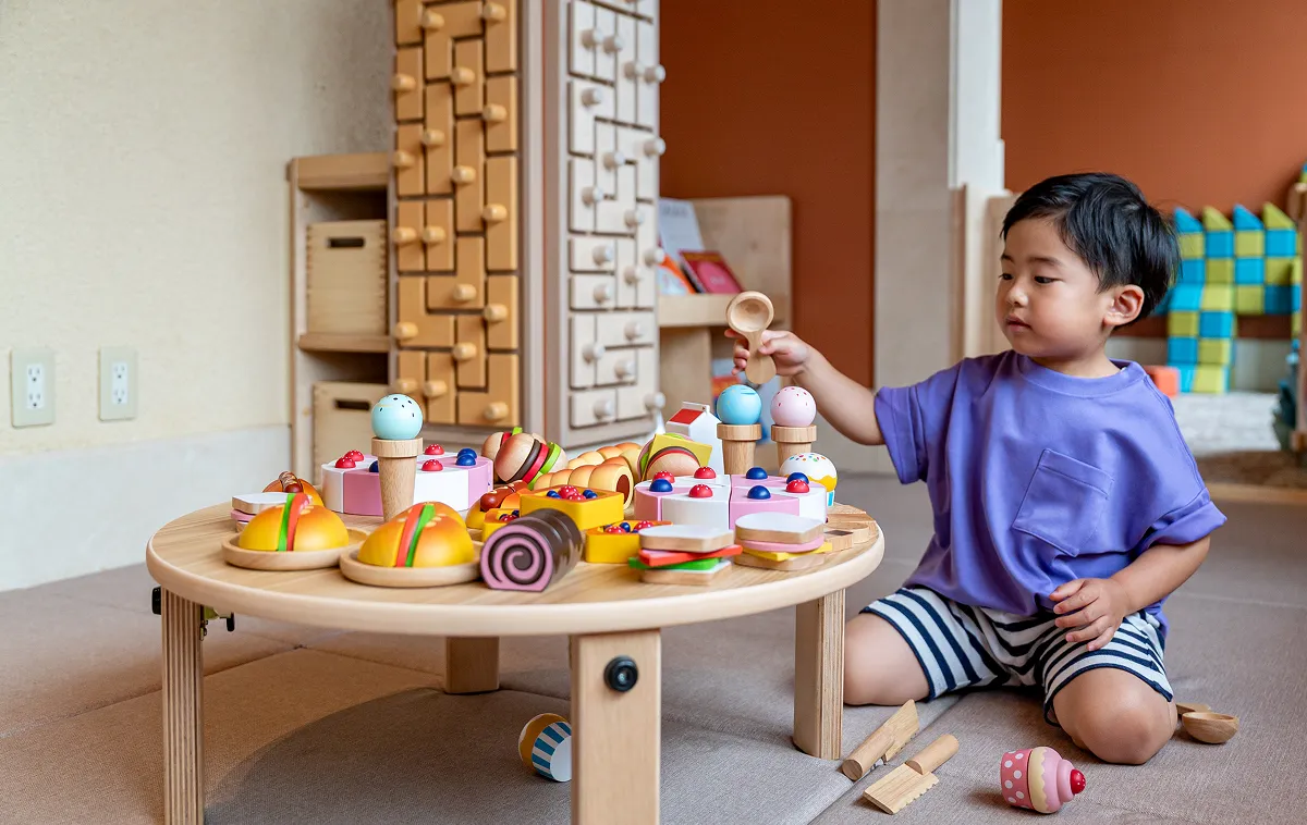 KIDS OASIS에서 나무 장난감으로 노는 유아