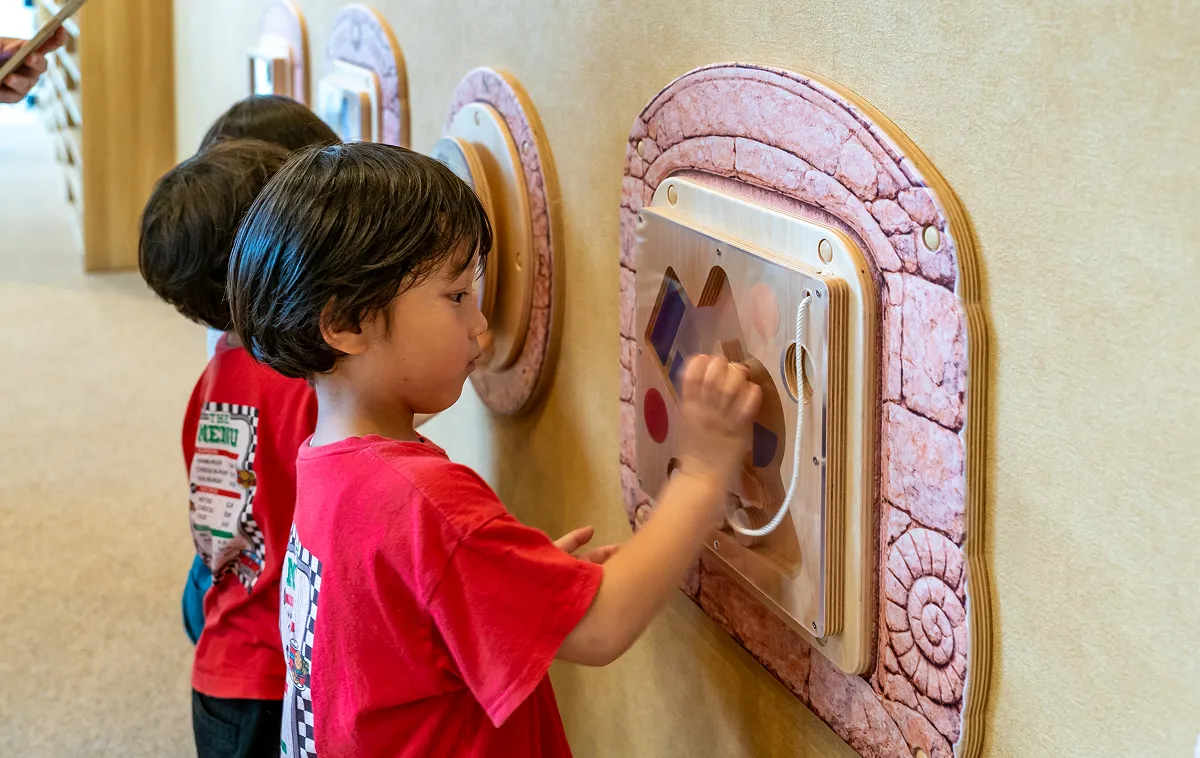 KIDS OASIS의 벽면 패널로 노는 아이들