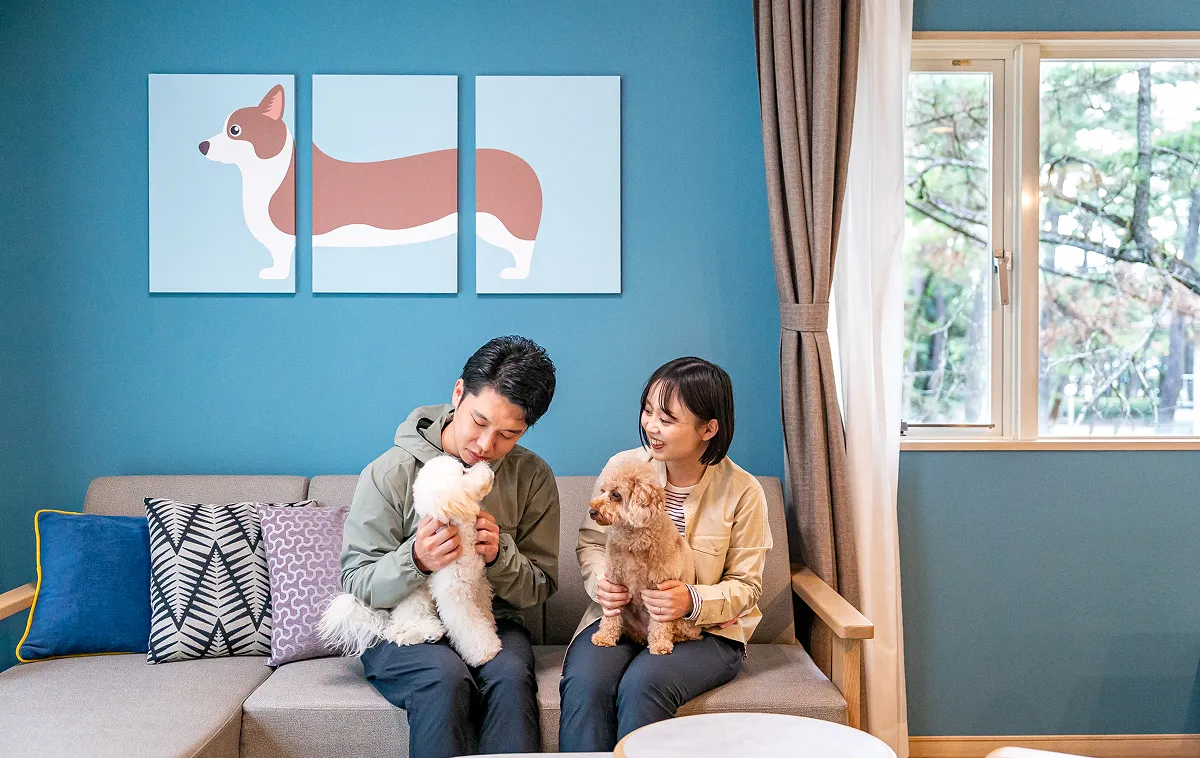 개 친절한 방에서 휴식을 취하는 두 사람과 애견
